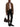 Model carrying the Acne Studios Camero chocolate brown leather camera bag with a brown jacket and black trousers